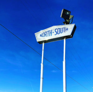 Vintage North South signage against a blue winter sky