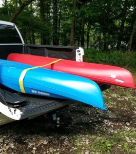 A red & blue kayak in the back of a white pick-up truck at the Henderson Sloughs.